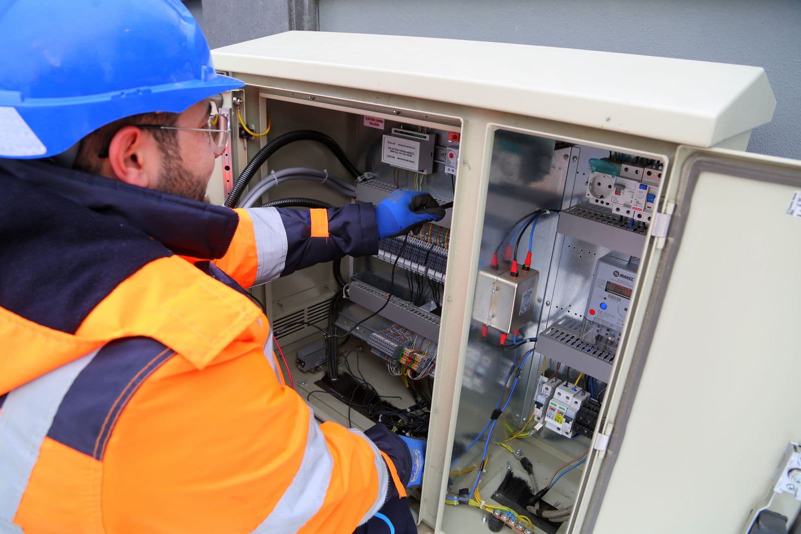 Engineer commissioning a building control and metering cabinet