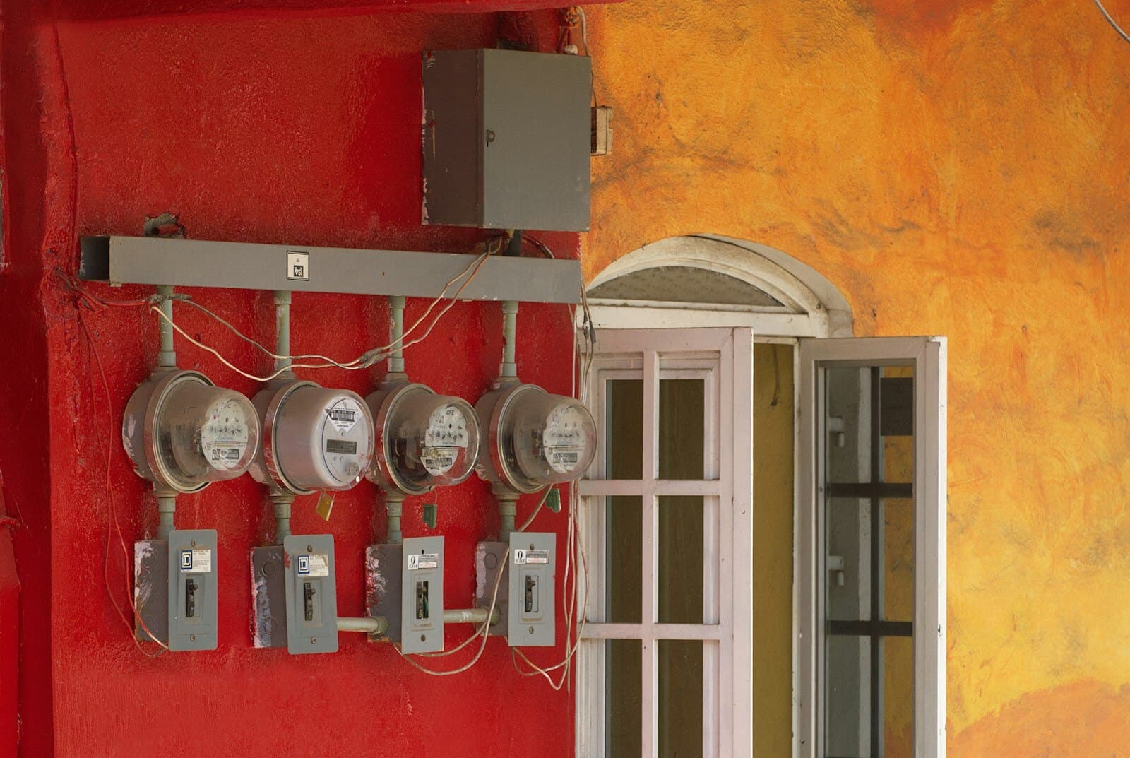 A row of analogue electricity meters mounted on a wall