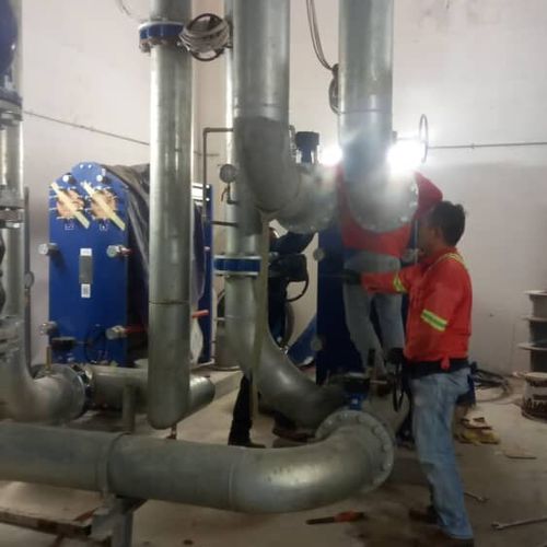 Chilled water plant pipework and heat exchanger with a technician on site