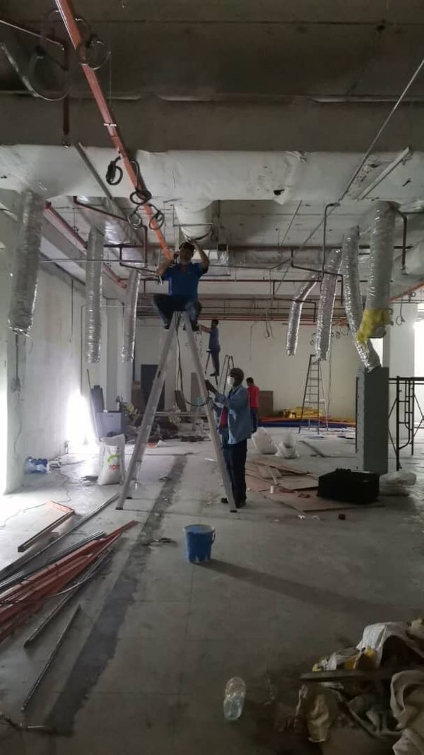 BMS installation on a live construction site with ductwork and ladders