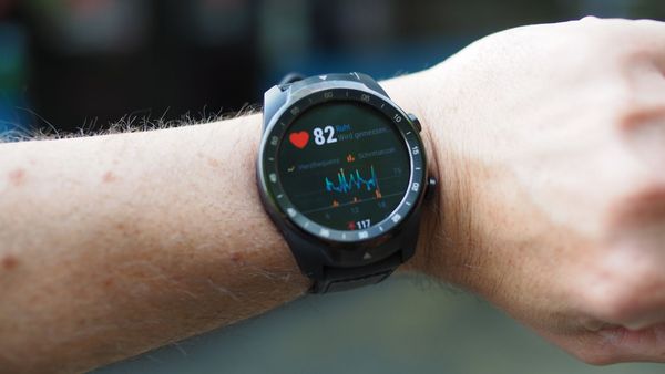 A smartwatch on a wrist showing a live heart-rate reading and trend graph, the everyday example of continuous monitoring
