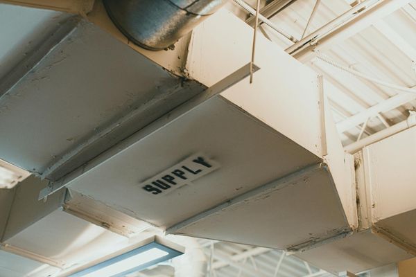 White HVAC supply air ductwork below a building roof